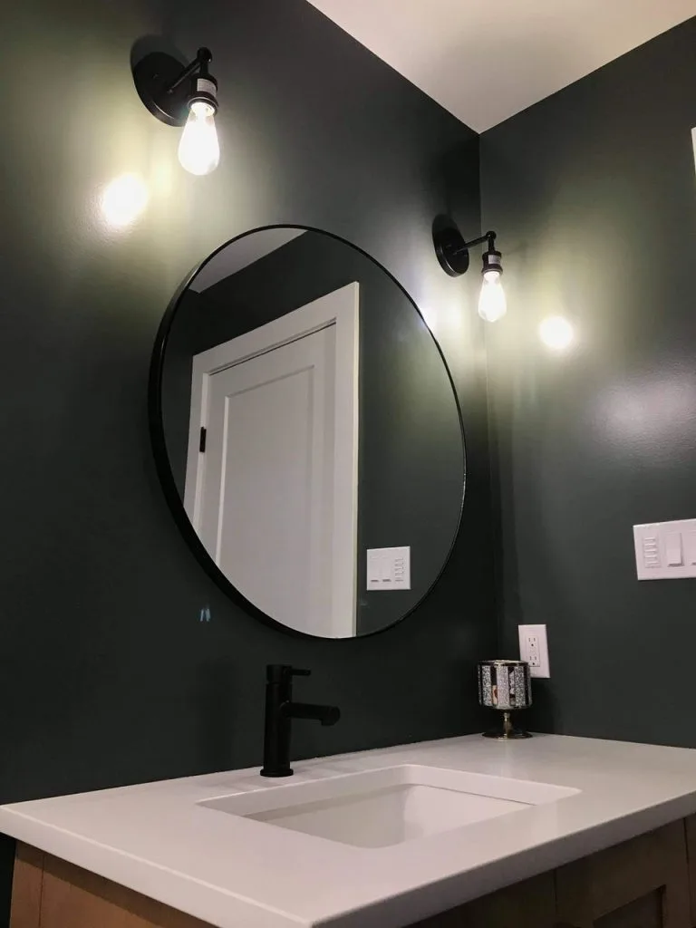 A modern bathroom about sleek design with a circular mirror and warm lighting