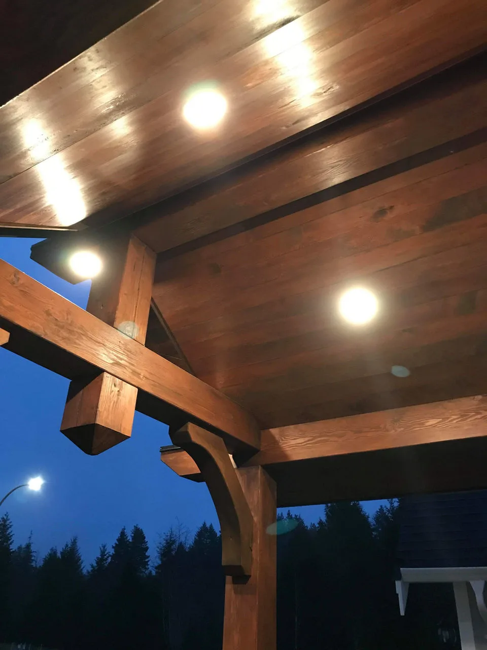 LED installs create a warm ambiance with yellow lights illuminating a wooden ceiling at twilight