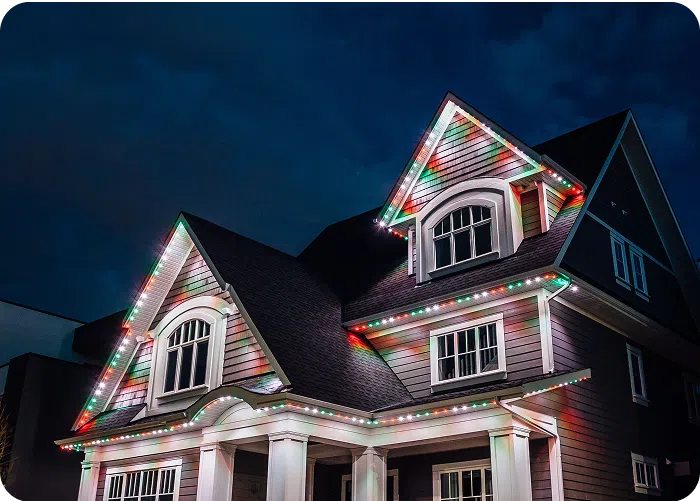 Gemstone Lights illuminate a beautifully decorated house against a starry night sky