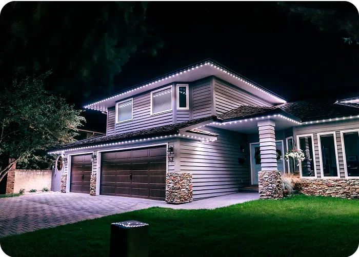 Gemstone Lights illuminate a beautifully designed house at night, highlighting its elegant architecture