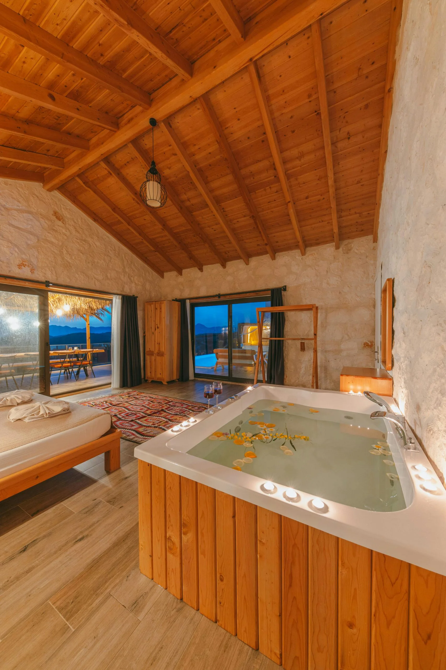 Hot tub installation in a cozy rustic room with wooden ceiling and large windows