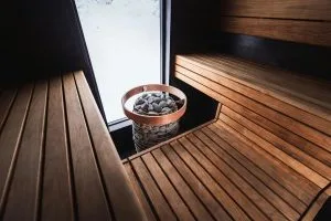 Sauna installation features wooden benches and a stone-filled heater for a serene atmosphere