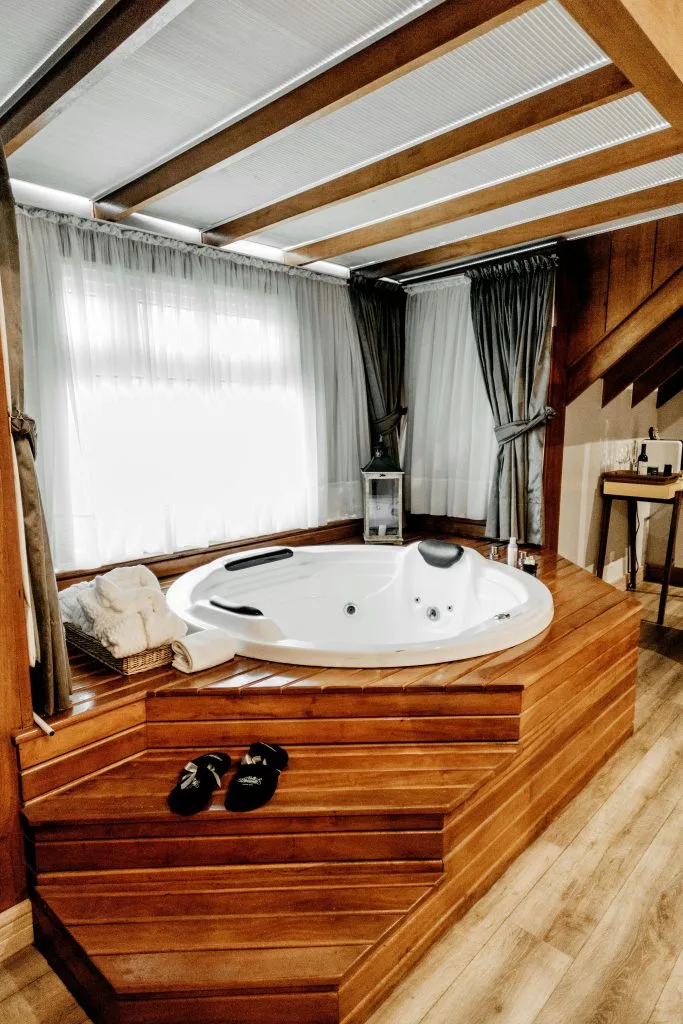 Hot tub installation in a cozy bathroom with wooden steps and soft lighting