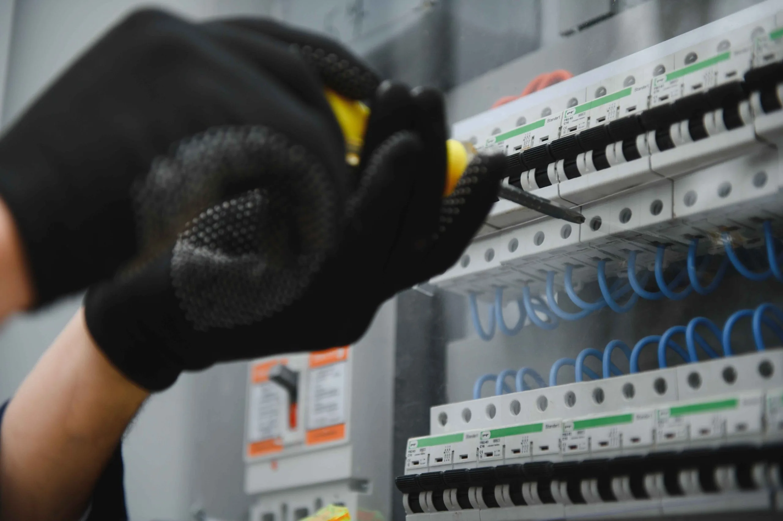 Person performing an electrical panel upgrade in Port Alberni with a screwdriver