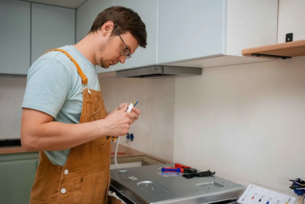 Electrical troubleshooting in a modern kitchen as a person repairs an appliance