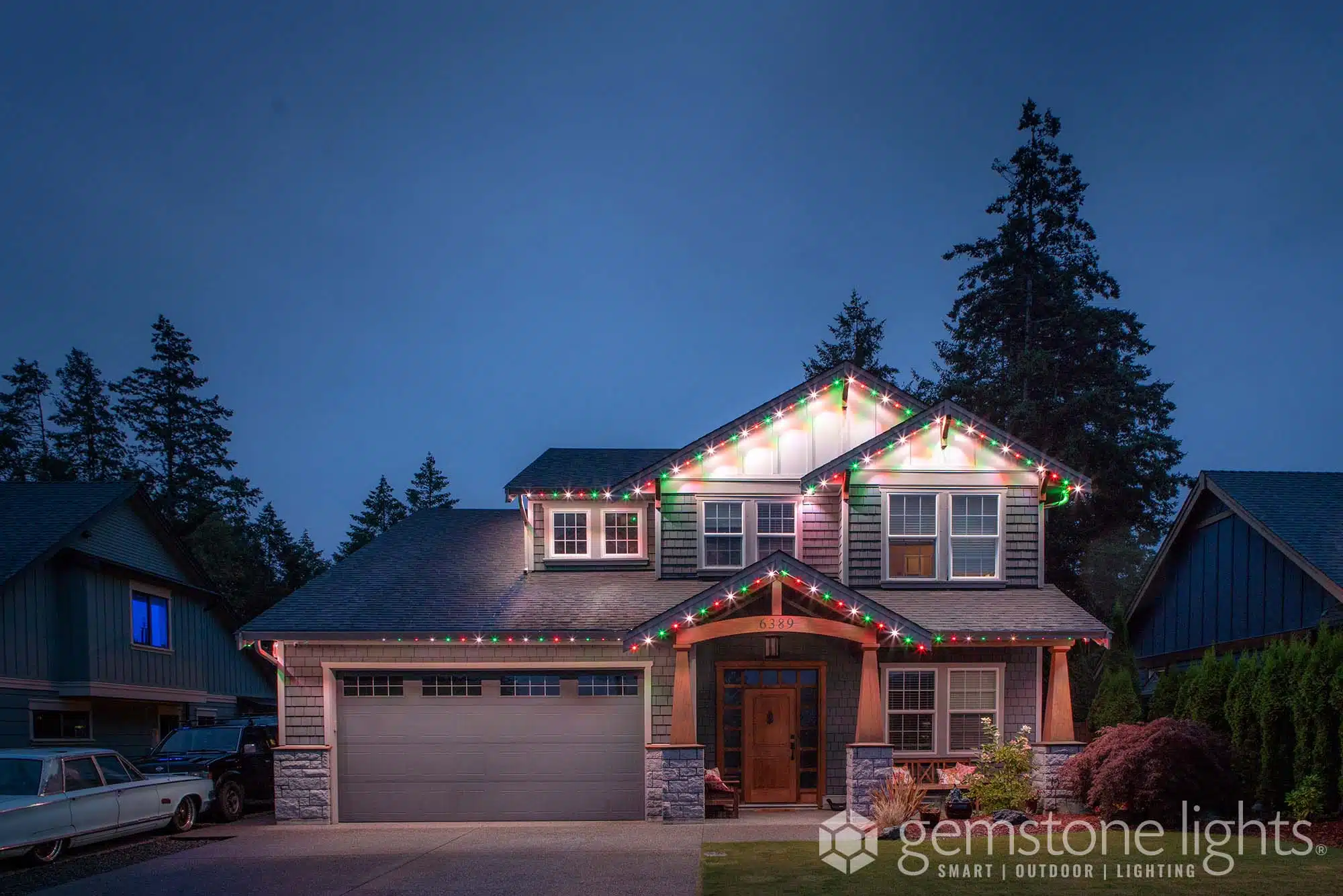 A beautifully decorated house glows with festive lights at dusk