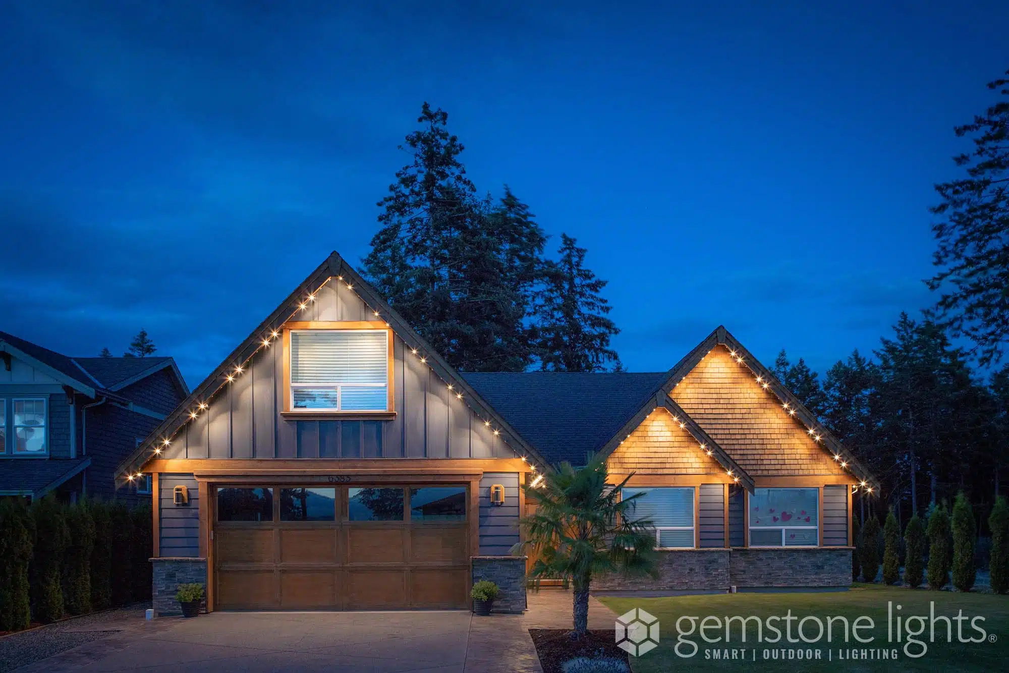 A beautifully lit modern house is showcased against a twilight sky